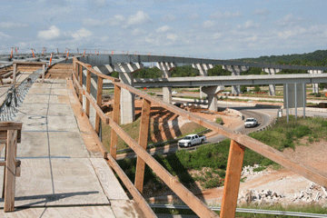 Contractor crews must build concrete forms on the girders of the bridges